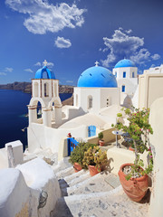 Wall Mural - View of blue dome church in Oia village on Santorini island