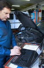 mechanic repairs a car in a garage