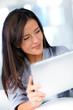 © goodluz - Young woman at home using electronic tablet