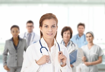 Wall Mural - Young female doctor in front of medical team