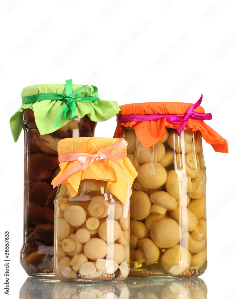 delicious marinated mushrooms in the glass jars isolated