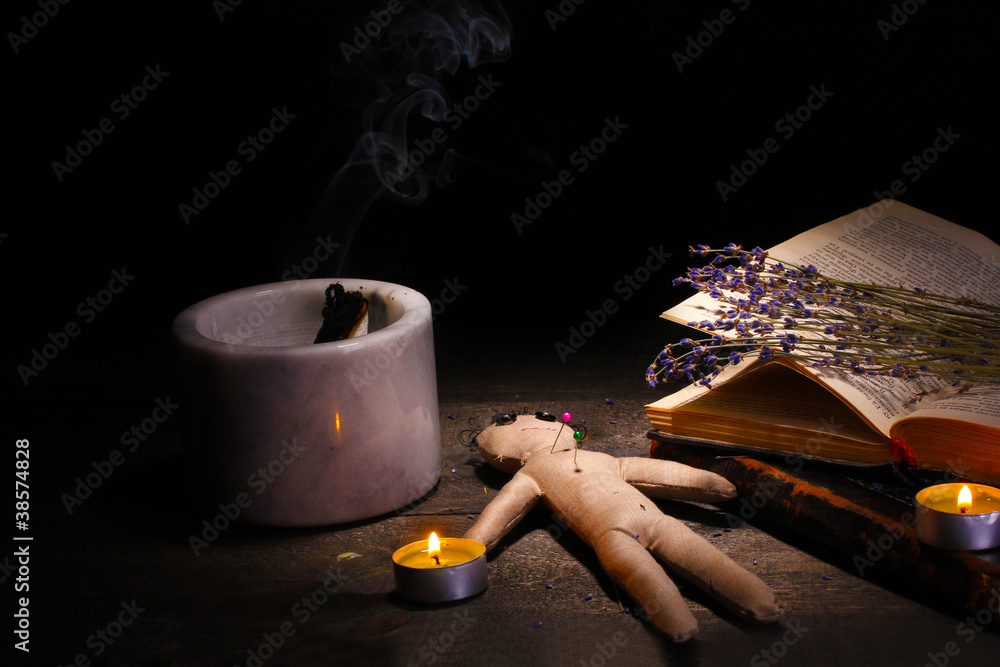 Voodoo doll boy on a wooden table in the candlelight