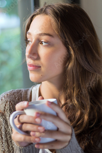 Fotografie, Obraz portrait of happy young woman having coffee at home