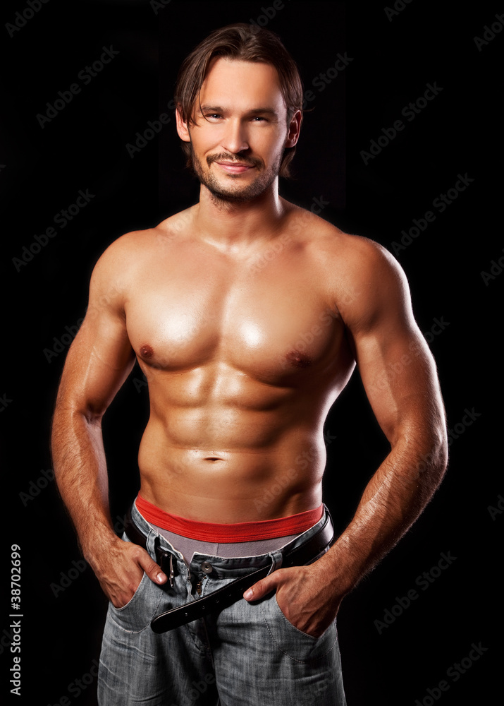 handsome powerful muscular man isolated on black - obrazy, fototapety, plakaty 