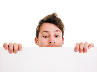 young man holding a blank board and looking down. isolated on wh