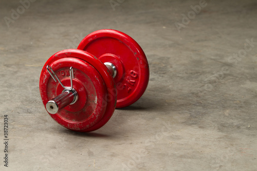 Board z aluminiowym obramowaniem Czerwoni dumbbells na cementowej podłoga - bawją się pojęcie