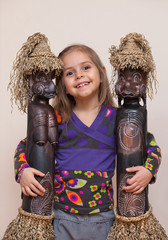 Little girl with two ethnic dolls