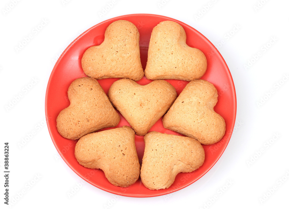 Heart-shaped cookies on red saucer isolated on white