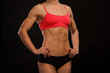 © Nobilior - Female fitness bodybuilder posing against black background
