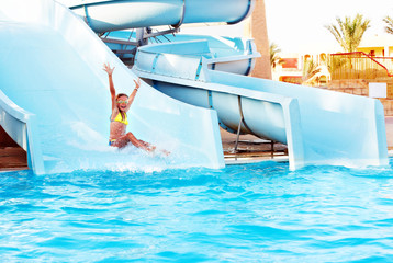 Child on water slide at aquapark.