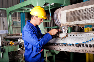 industrial mechanic repairing heavy industry machine