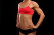 © Nobilior - Muscular female body against black background