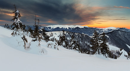 Wall Mural - Sunset in winter mountain with dramatic sky