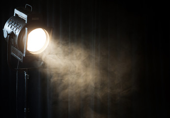 vintage theatre spot light on black curtain with smoke