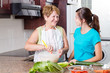 © michaeljung - happy grandma talking to granddaughter in kitchen while cooking