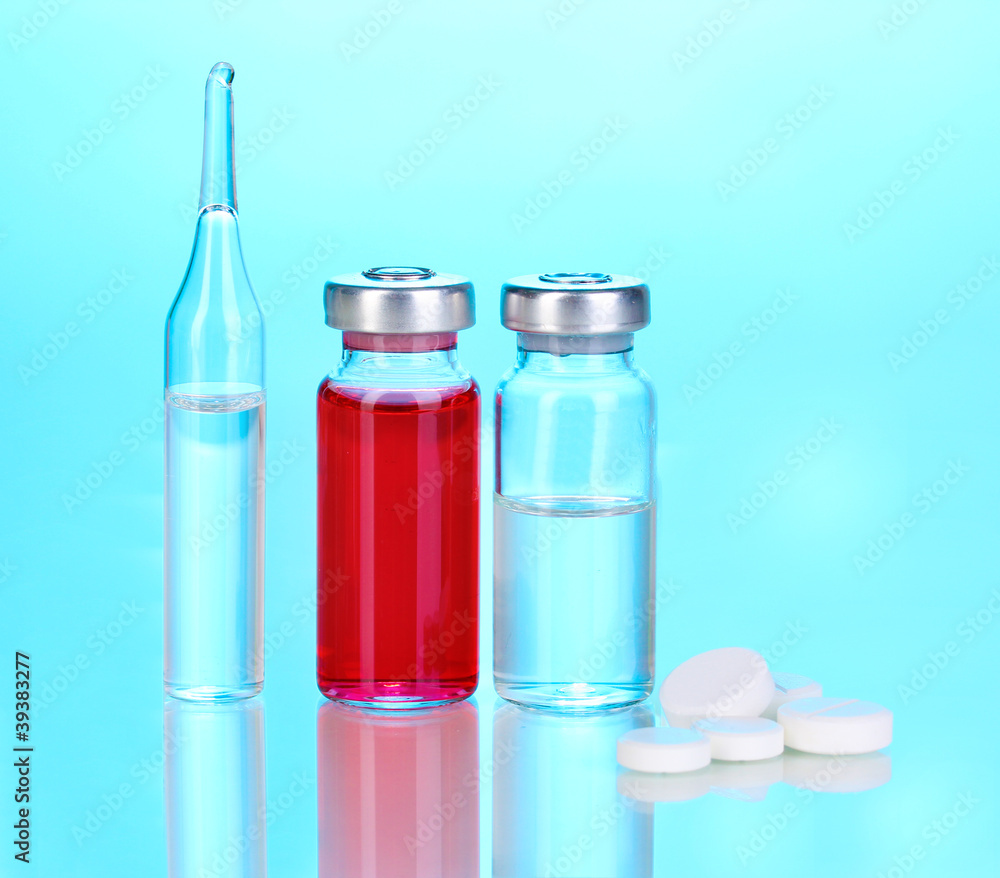 Tablets and ampoules on blue background