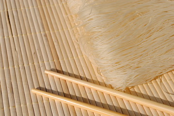 rice needles on a bamboo place mat with chopsticks