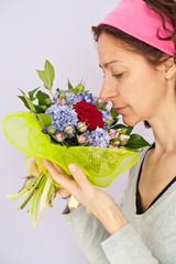 Portrait of pretty woman smelling a flower's bouquet.