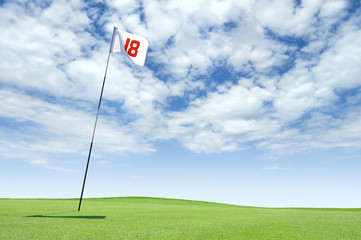 Golf flag at hole 18 on the putting green