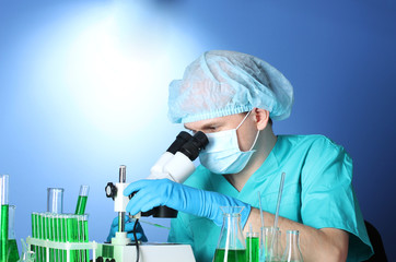 scientist looking at microscope in chemistry laboratory