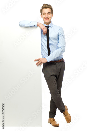 Fotografía Businessman leaning against blank billboard