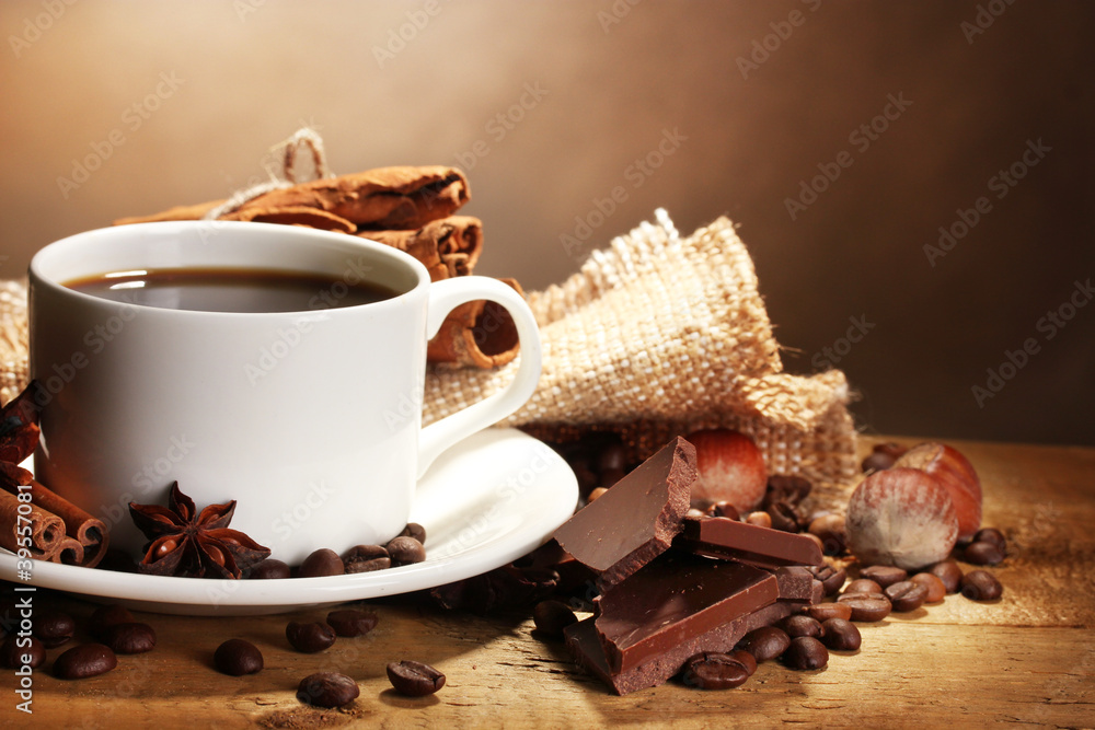 coffee cup and beans, cinnamon sticks, nuts and chocolate