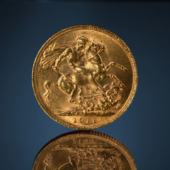 old golden sovereign coin on blue