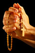 Christian human praying with rosary in hands