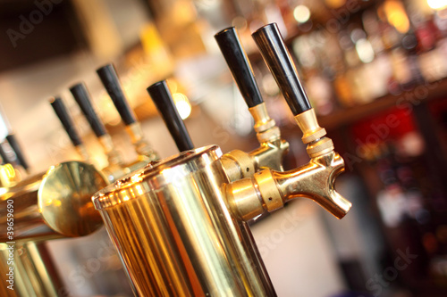 Fényképezés  Row of beer taps in a tavern.