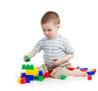© Oksana Kuzmina - little cheerful child playing with construction set over white b
