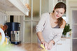 © lightpoet - Young woman doing housework, cleaning the kitchen