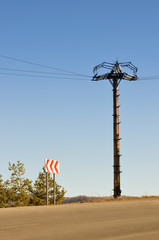 Electrical column in field under blue sky