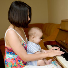 mother and an adorable toddler playing on the piano