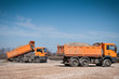 The orange truck unloading sand at the site