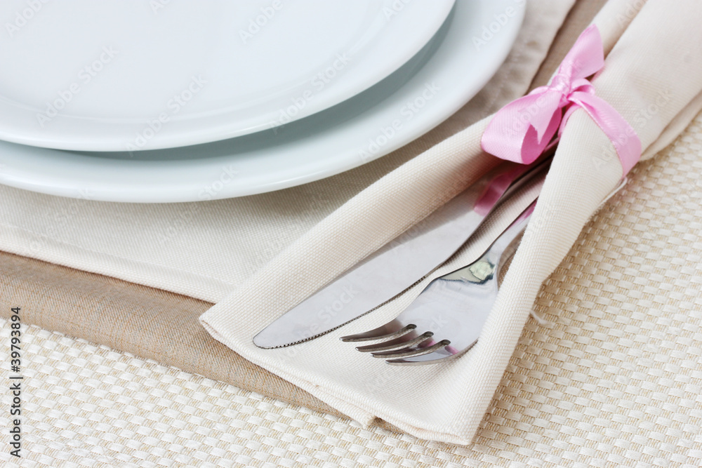 Table setting with fork, knife, plates, and napkin