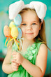 sweet little girl dressed in Easter bunny ears holding colorfull