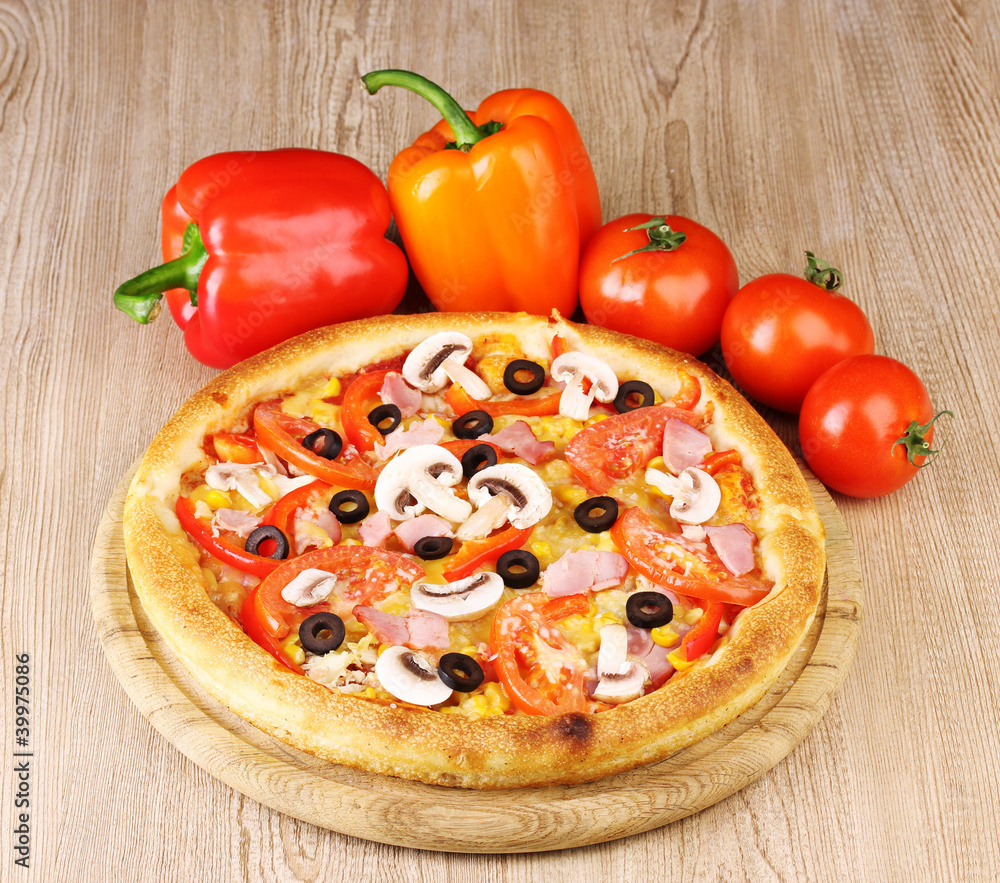 Aromatic pizza with vegetables on wooden background