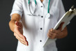 © Monkey Business - American nurse extending hand to shake