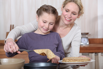 Mother and daughter making crepes together