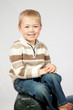 © Allen Penton - blond boy sitting on a bench smiling at the camera