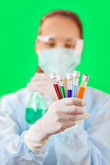 Canvas Print - Medical test tubes with fluid sample in doctor's hand on green b