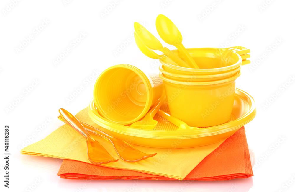 Bright yellow plastic tableware and napkins isolated on white