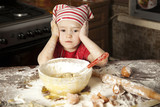 Fototapeta  - little chef in the kitchen wearing an apron and headscarf