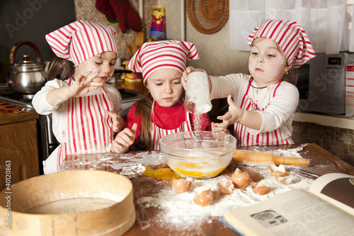 Fotografía Three little chefs enjoying in the kitchen making big mess. Litt