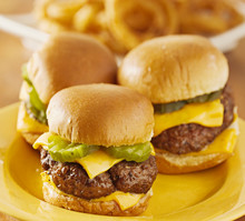 Three Burger Sliders With Cheese And Pickle