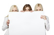 Three women peeking over edge of blank billboard