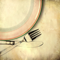 Knife, plate and fork on grunge background