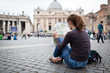 © lightpoet - Pretty young female tourist studying a map at St. Peter's square