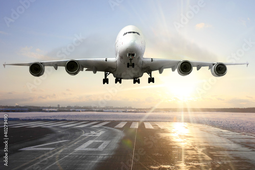 Nowoczesny obraz na płótnie Passenger airplane landing on runway in airport. Evening