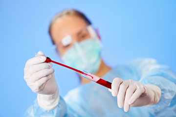 Wall Mural - Young woman doctor making blood analysis with test tube and drop